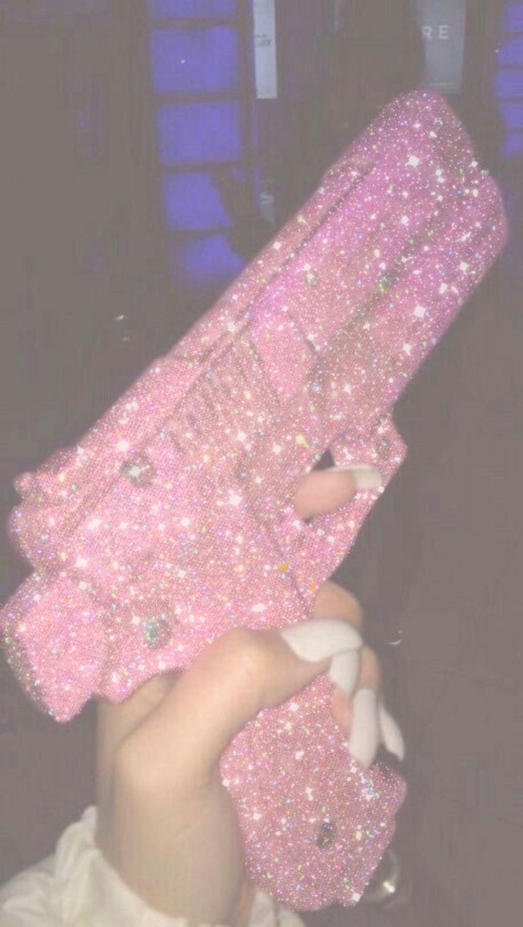 Розовый пистолет в руке