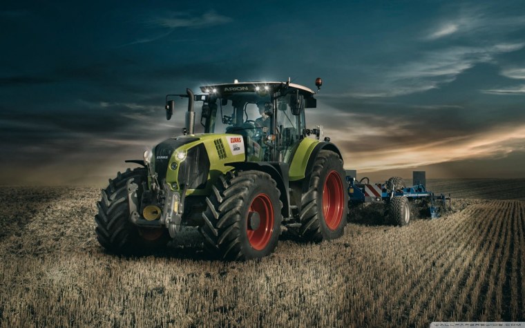 Трактор John Deere на зеленом поле