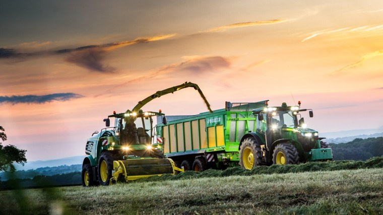 Трактор John Deere на зеленом поле