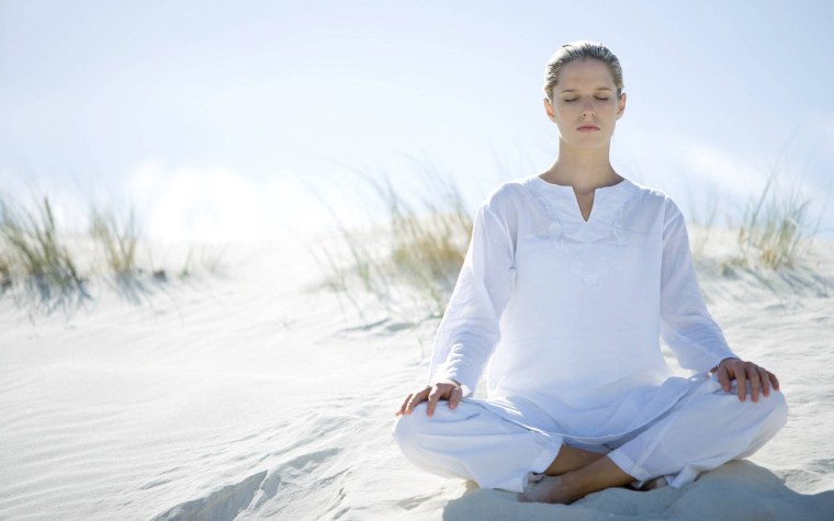 Женщина медитирует на природе