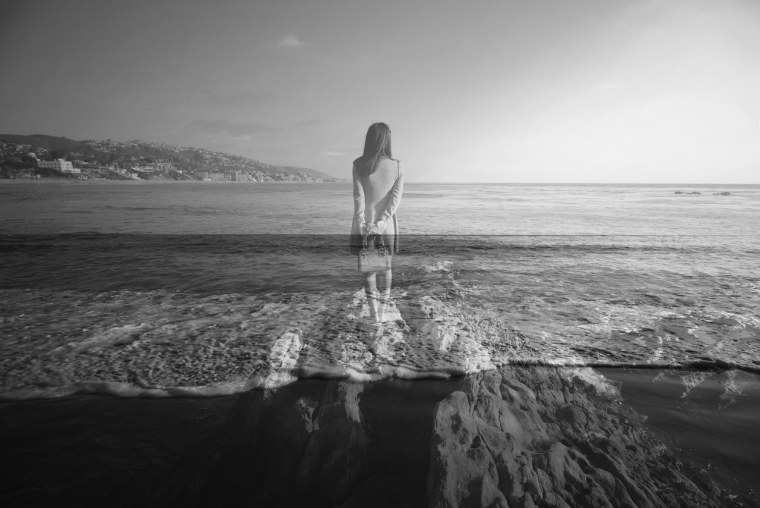 Женщина сидит спиной на мостике