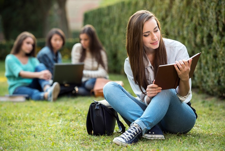 Студент с книжкой в парке