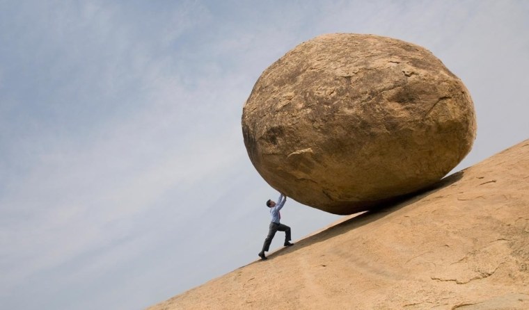 Человек тащит камень