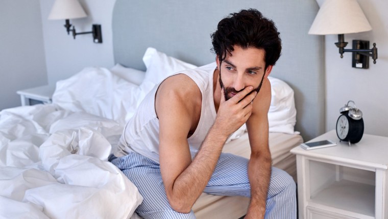 Человек сидит на кровати