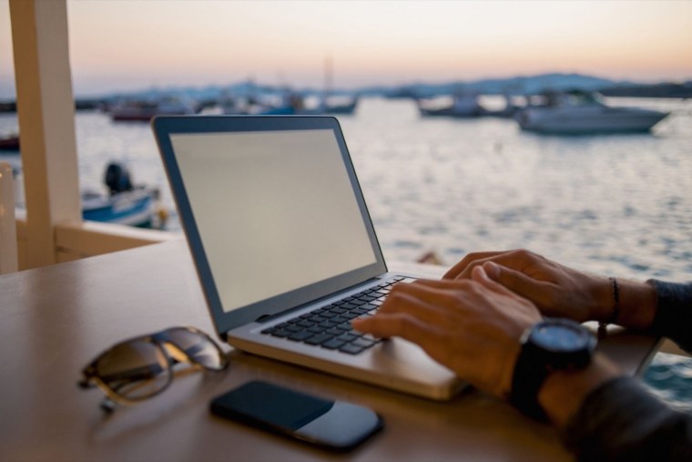 Мужчина с ноутбуком на море