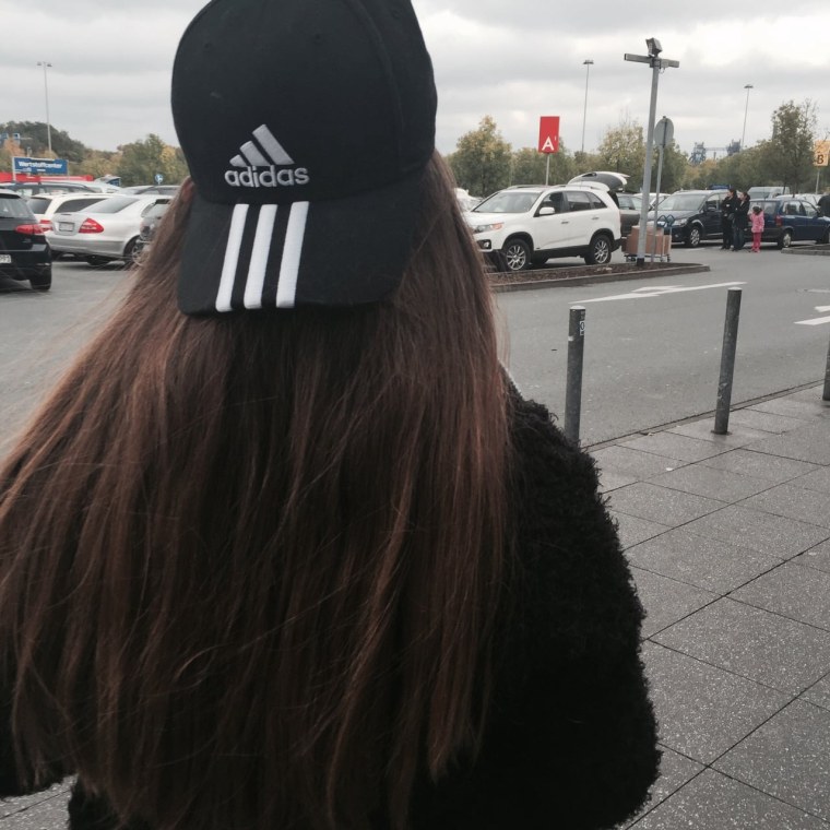 Девушка в бейсболке со спины