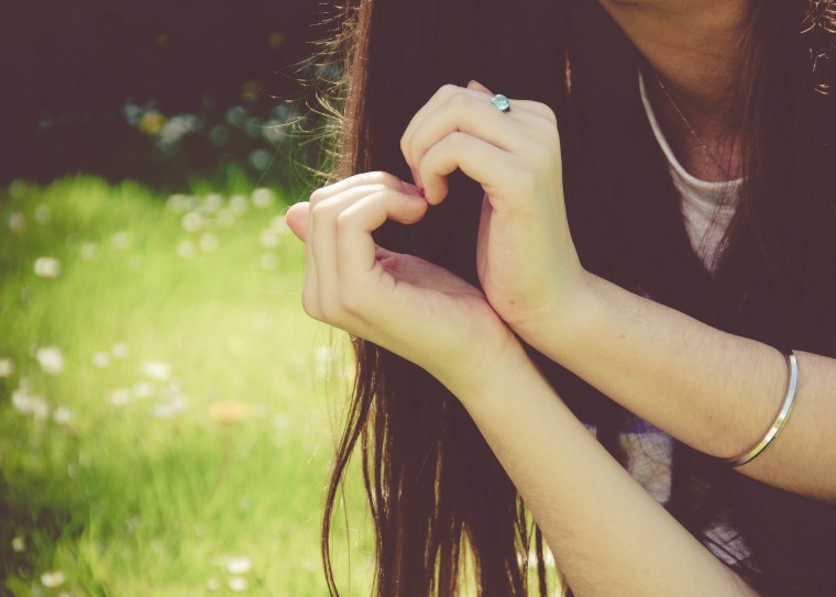 Девушка показывает сердце