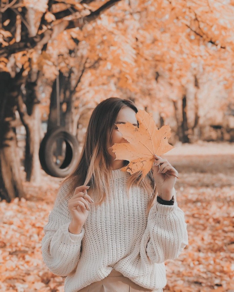 Женские ноги в осенней листве