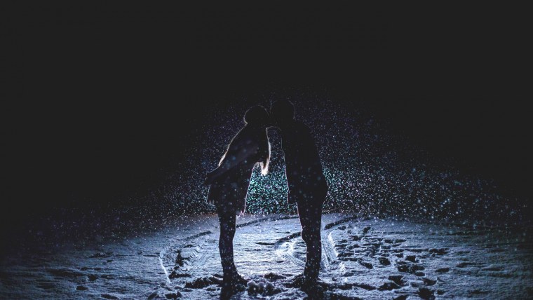 Силуэты мужчины и женщины на черном фоне