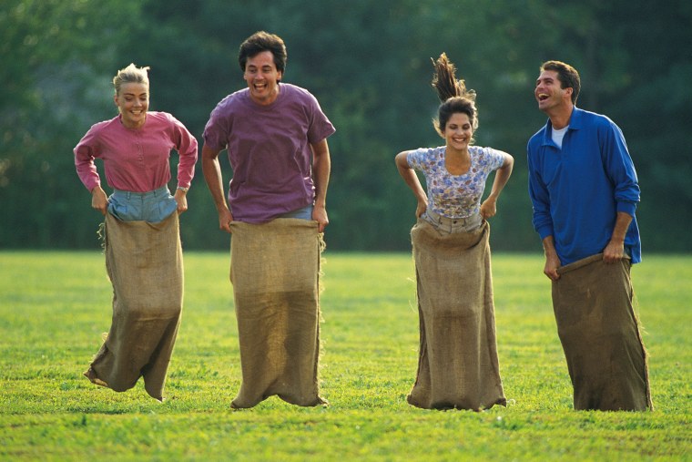 Люди прыгают в мешках