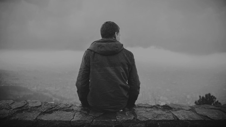 Парень в капюшоне сидит