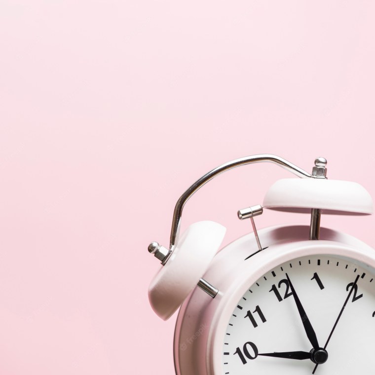 Будильник на розовом фоне
