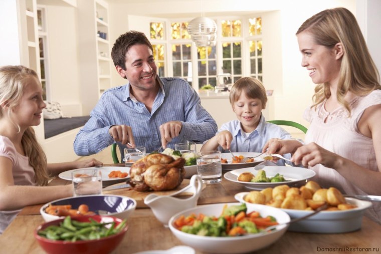 Семья ужинает за столом