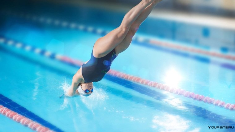 Девушка ныряет в бассейн