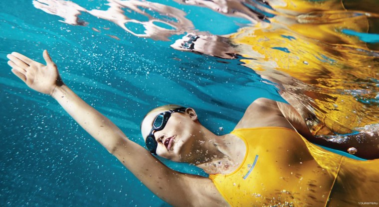 Девушка плывет в бассейне