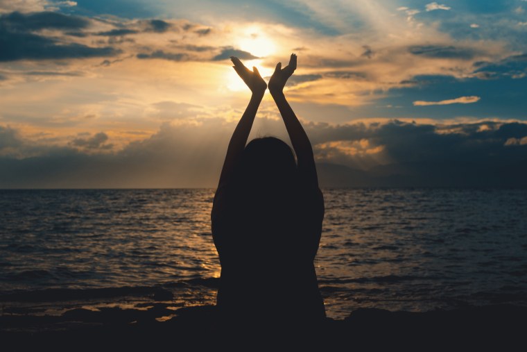 Девушка на закате с поднятыми руками