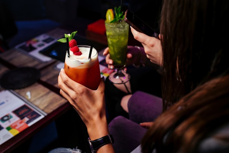 Девушка в бассейне с коктейлем