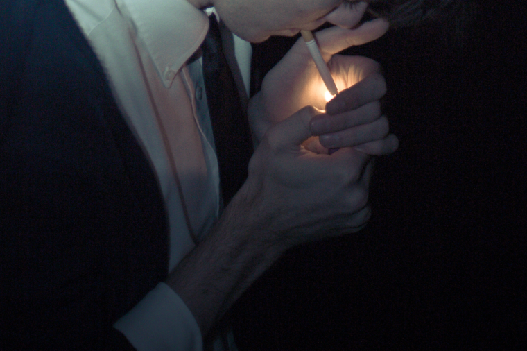 Парень с сигаретой в темноте