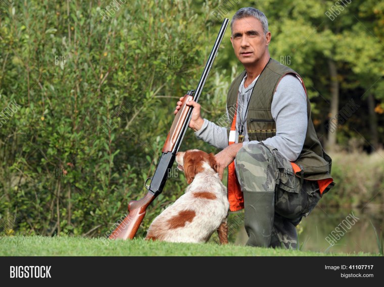 Красивые молодые мужчины охотники с оружием