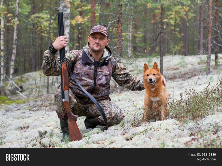 Охотник сидит с ружьем