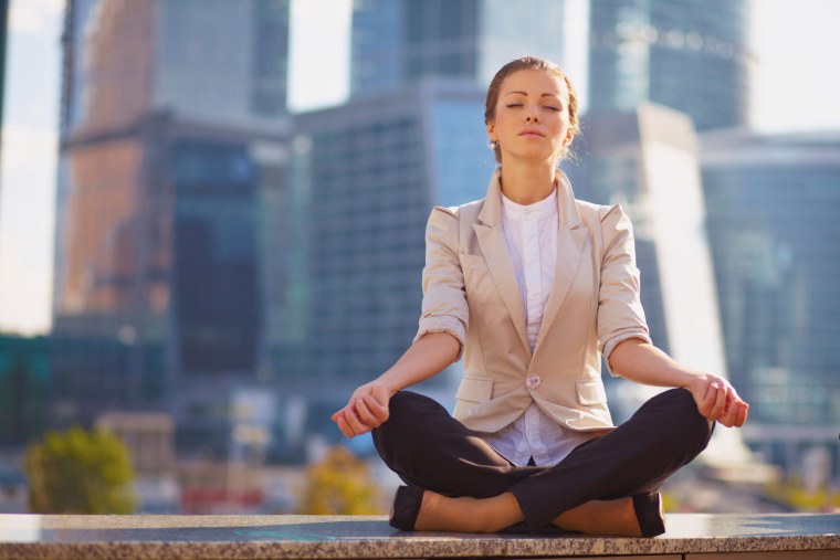 Девушка медитирует в офисе