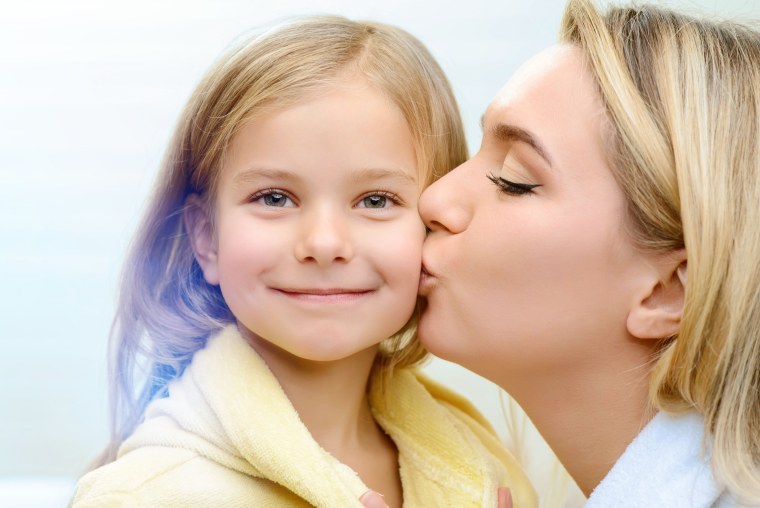 Мама целует дочку в щечку