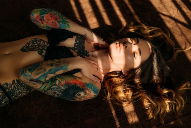 Девушка с тату лежит