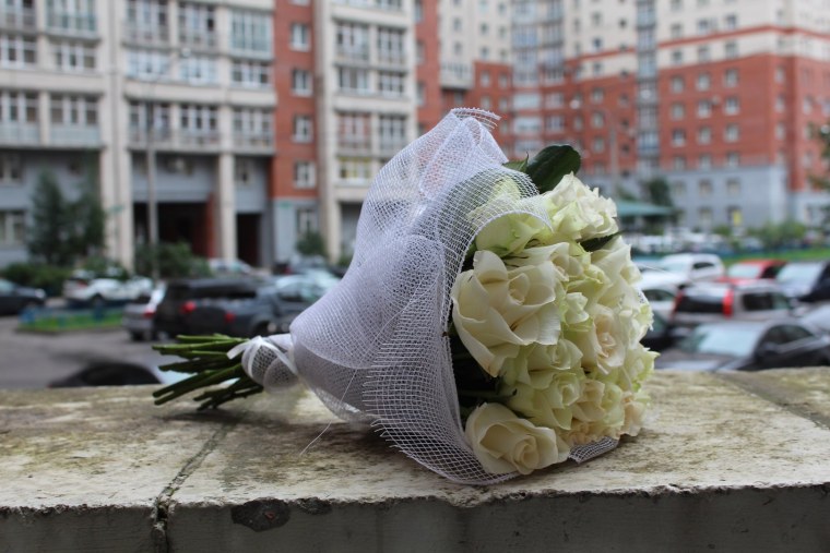 Букет из белых роз в сетке