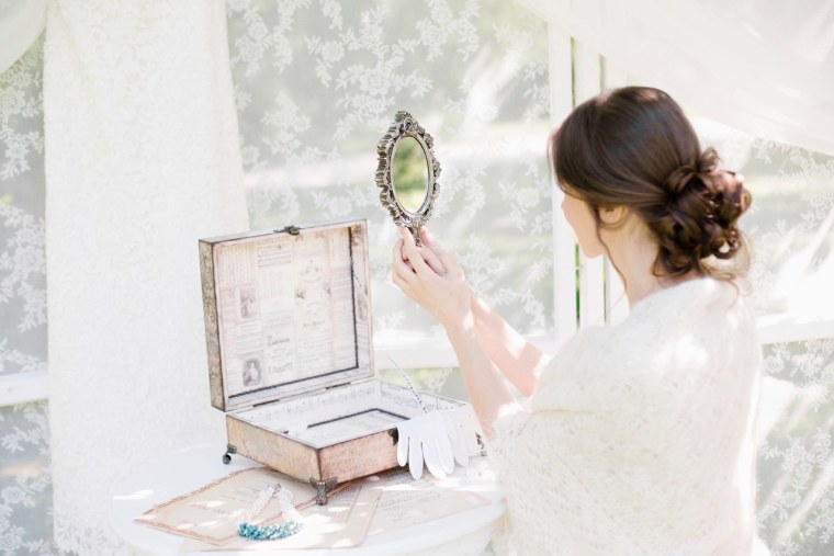 Девушка смотрится в зеркальце