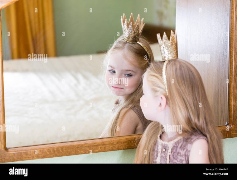 Девочка смотрится в зеркало