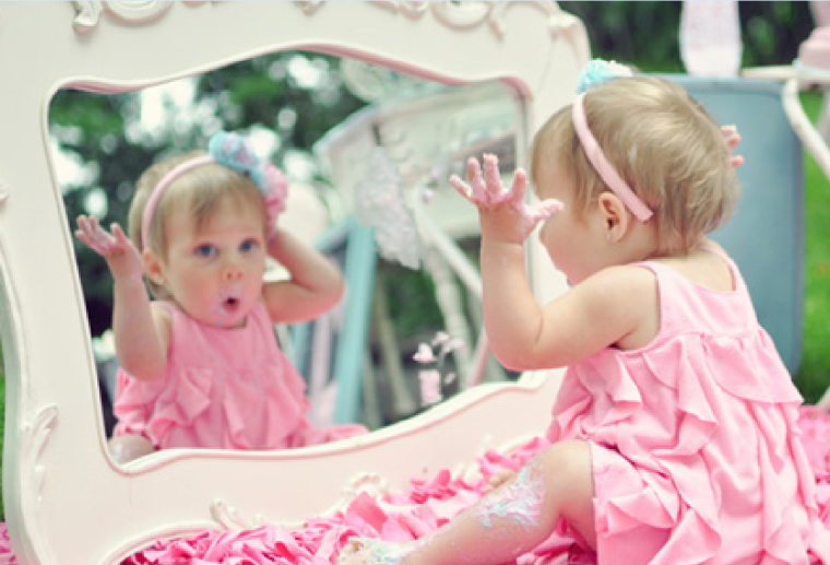 Девочка смотрится в зеркало