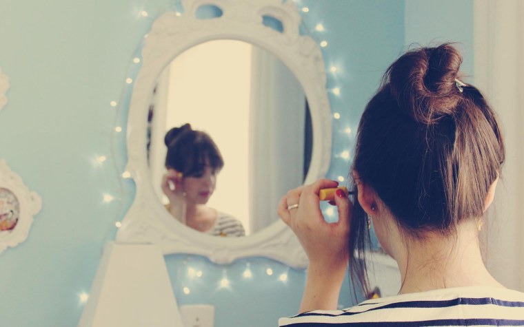 Девушка у зеркала со спины