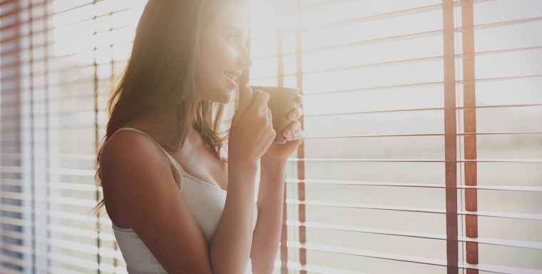 Девушка в солнечных лучах у окна