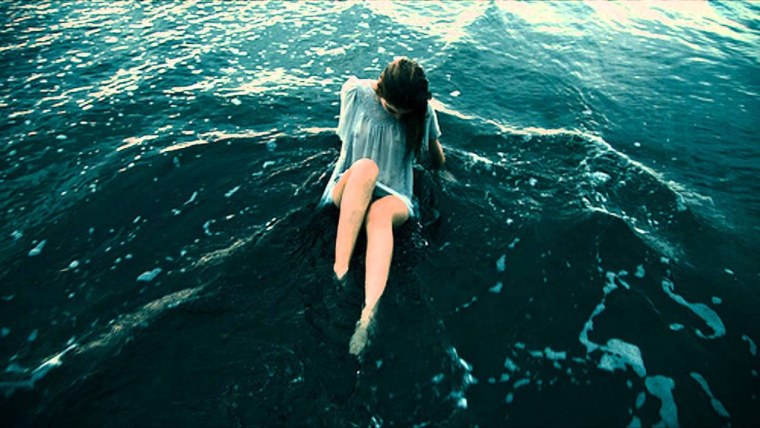 Девушка у океана спиной