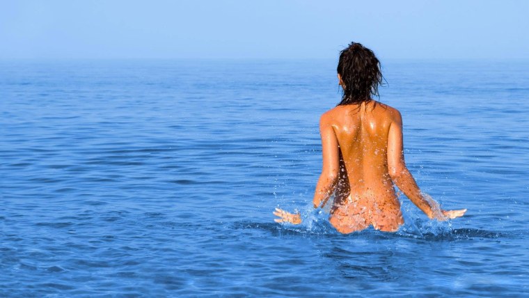 Девушка купается в море