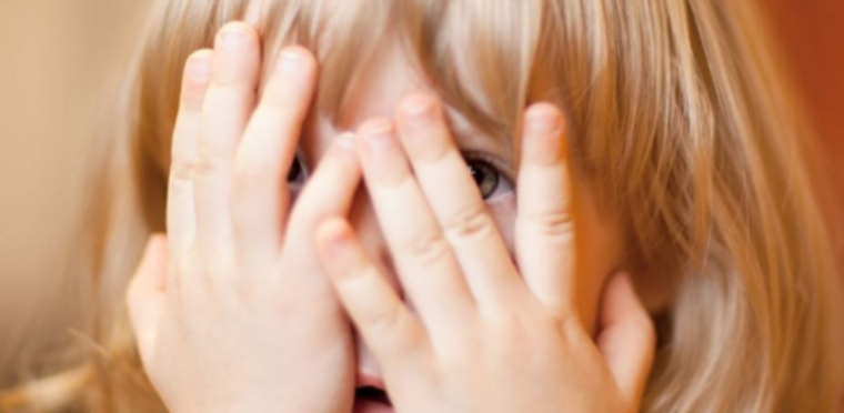Девочка закрывает лицо руками