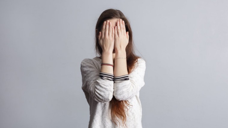 Подросток закрывающий руки одеждой