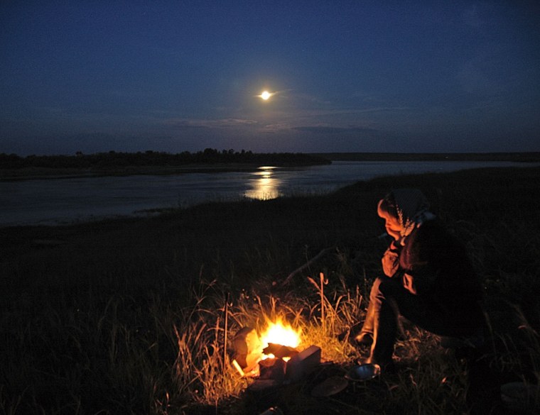 Костер на берегу реки ночью