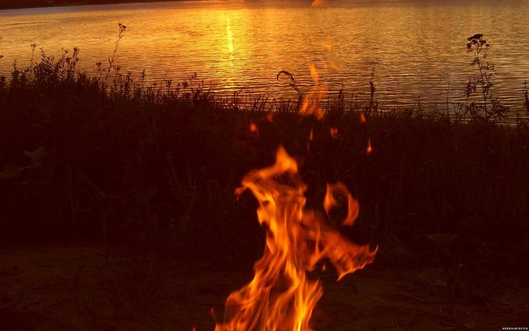 Костер на берегу реки ночью