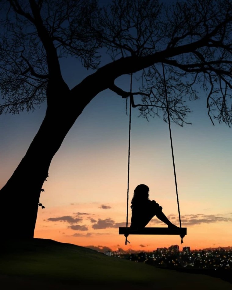 Девушка на качелях на закате