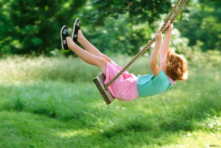 Девочка качается на качелях