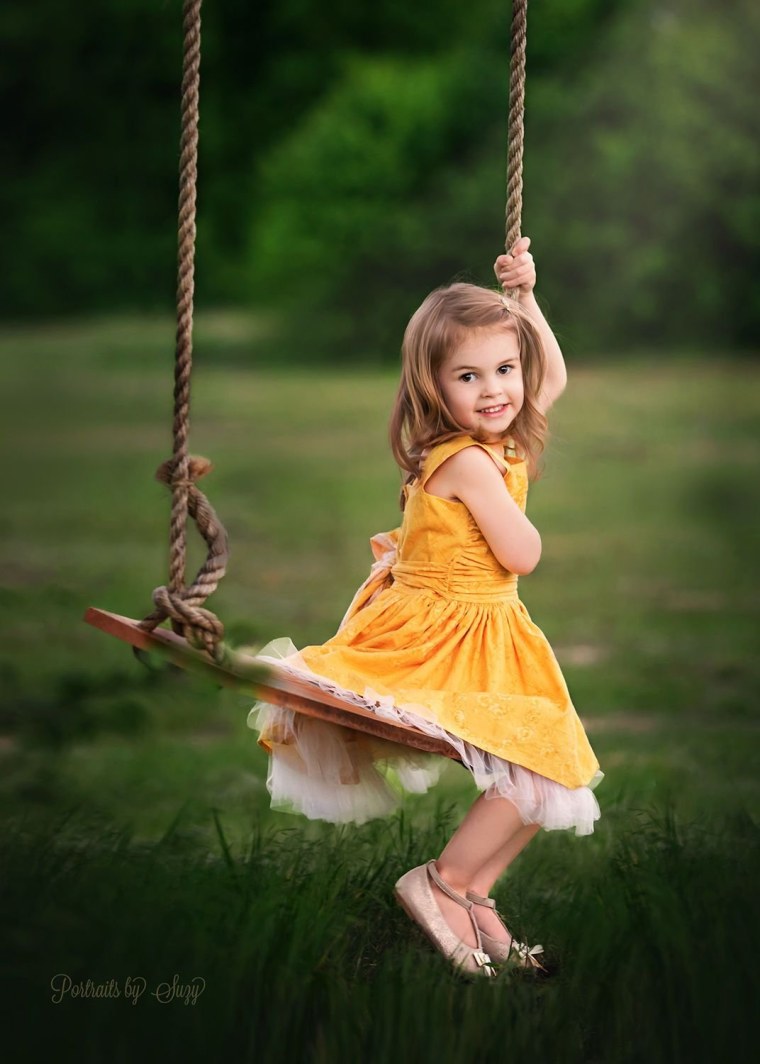 Девочка катается на качелях