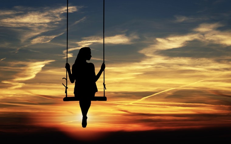 Девушка на качелях на закате