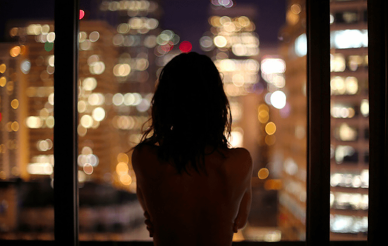 Девушка у окна со спины