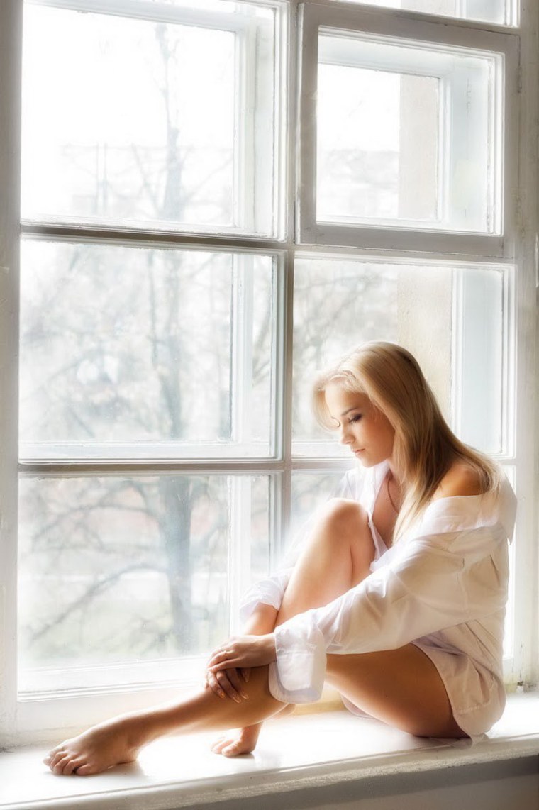 Девушка сидит на подоконнике