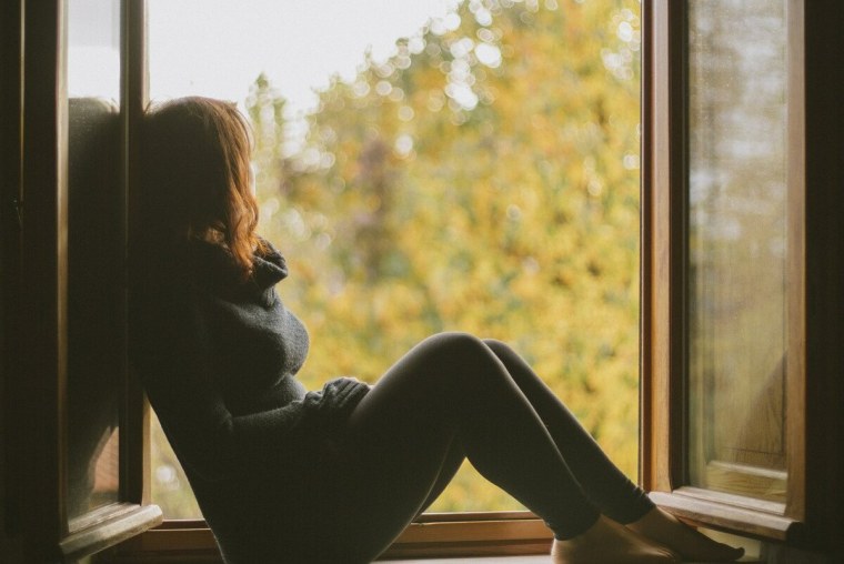 Девушка сидит на окне