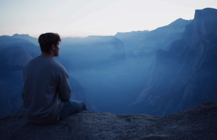 Человек сидит на скале