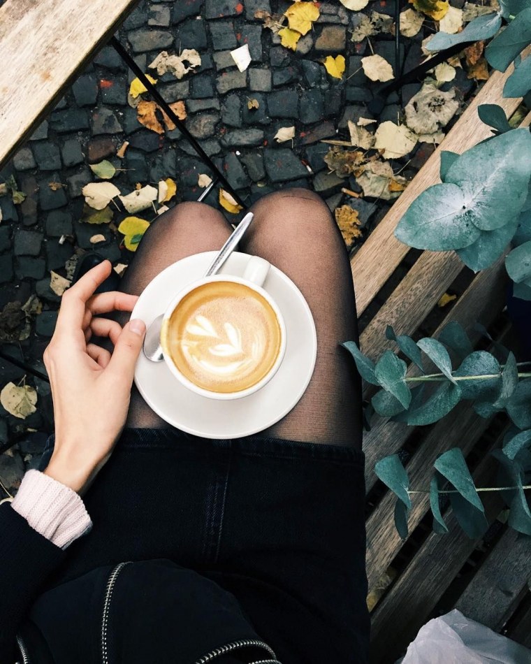 Девушка идет с кофе в руках