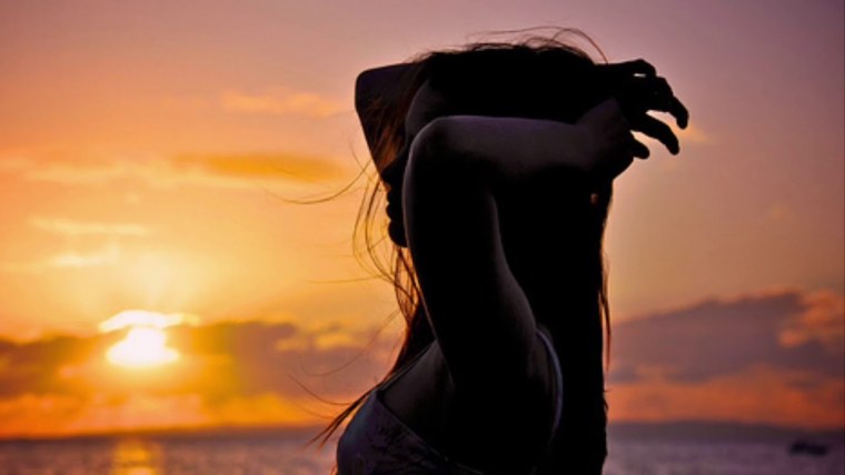 Брюнетка на закате со спины