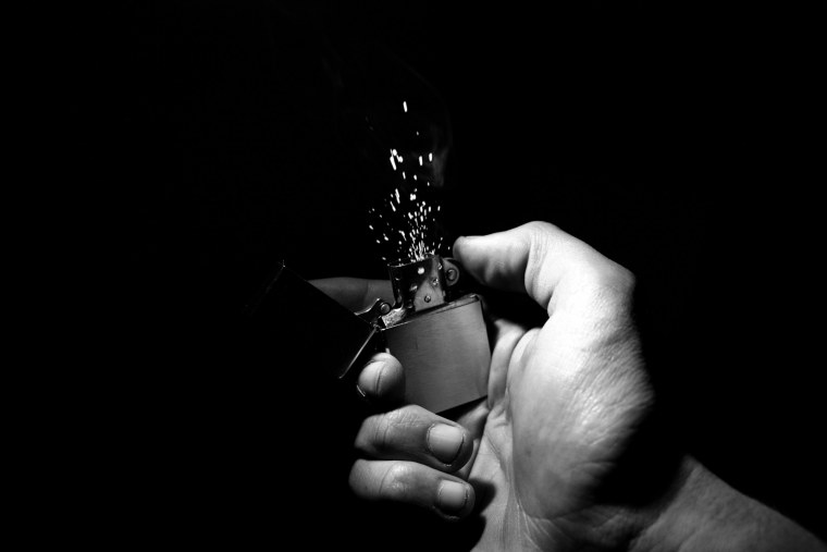 Мужская рука с зажигалкой